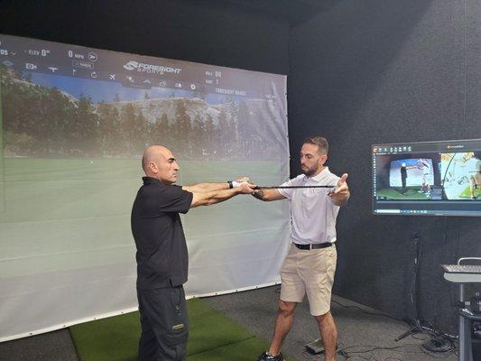 Instructor Brooks helping a client understand the relationship between the back of his hand the leading edge of the club.