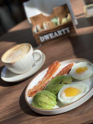 Poached eggs, avocado and bacon.  Cappuccino with almond milk