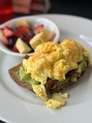 B.A.E Avocado Toast with a side of fresh fruit.