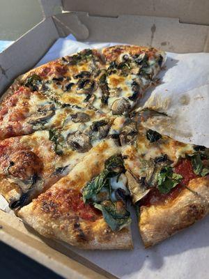 Small pizza with mushrooms, basil and spinach