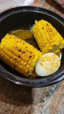 Corn on the cob with a boiled egg and seasoning on top