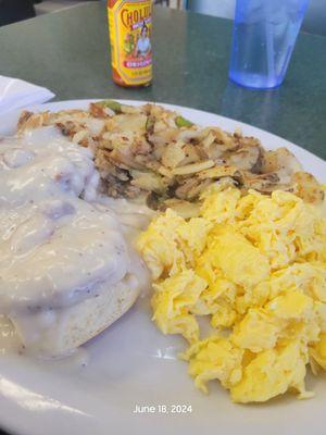 Country Breakfast with eggs, homestyle potatoes, and Biscuits topped with Sausages and sausage gravy.