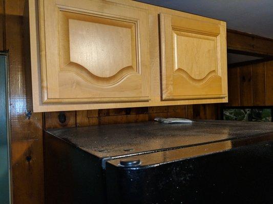 Upside down cabinet doors and unclean top of the fridge