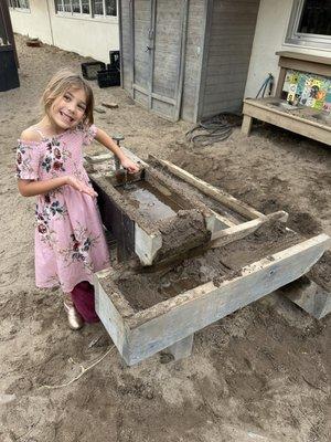 Child at the children's school playing in the mud kitchen.