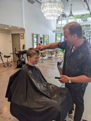 Young man getting the senior photo cut.