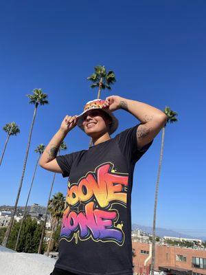 AC wears Groove Zone Merch  White bucket hat Black tshirt. GrooveZonemerch.com