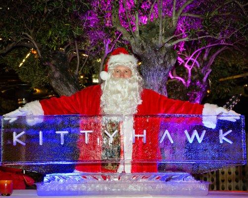 Hire Santa for the best corporate events. Santa Poses with Ice Sculpture at a Corporate Holiday party.