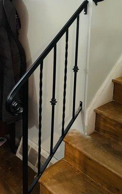 Custom indoor iron railing with alternating twisted balusters and collars.