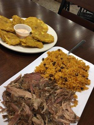 Lechon Saadi with yellow rice with a side of tostones