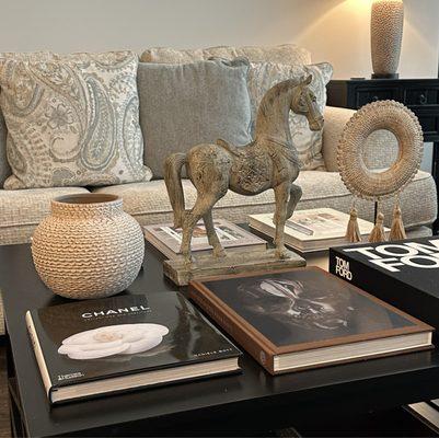 The trifecta of all coffee table trifectas. The horse, the round boho tassel and that chevron vase all lookes good together.