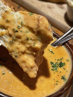 Dipping the bread in chicken red pepper soup.