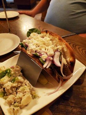 Gyro on taco stand with side of potato salad