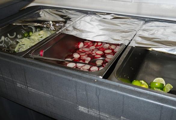 condiment bar: lime wedges, radish slices, sliced onion & jalapeno