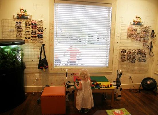 Children's frames are in the room nearest the door. The room also houses a fish tank, Legos, & children's books.