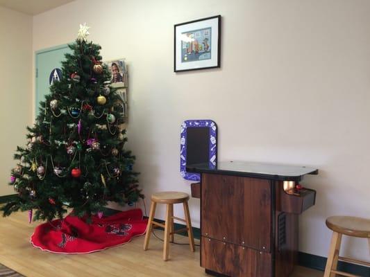 Waiting area with a pac man game table and a pretty Xmas tree.