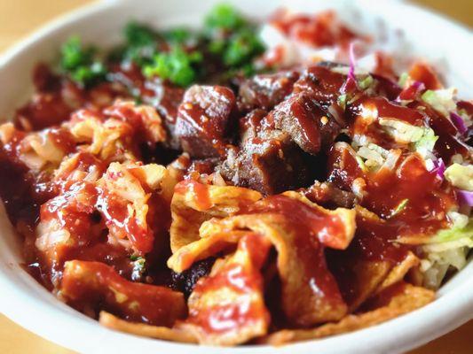 Close up a customized bowl with bulgogi beef and Mexican steak.