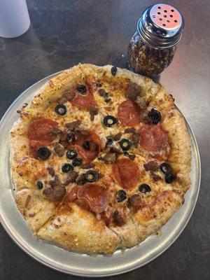 Stuffed crust with pepperoni sausage and olives. Taken next to shaker for size reference