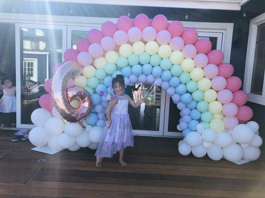 Rainbow balloon arch in pastel colors.