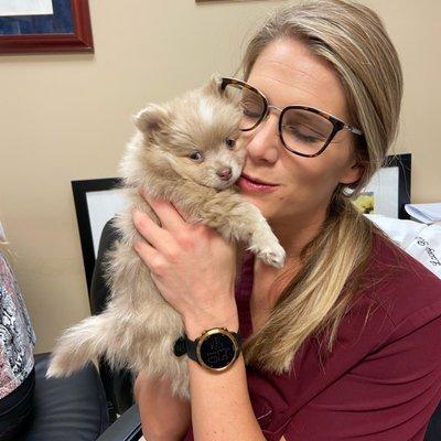 Dr. Rush loving on a pomeranian puppy.