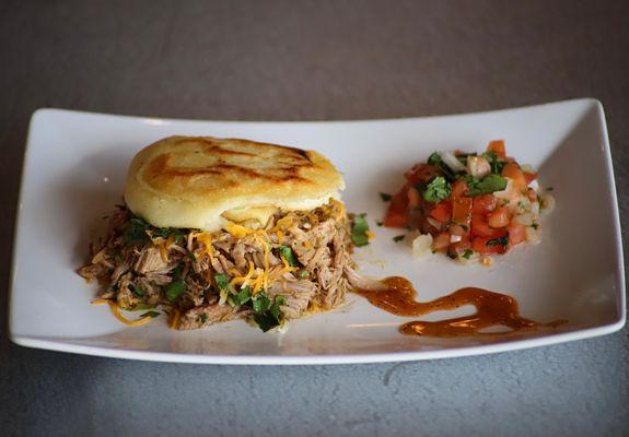 Venezuelan Arepa filled with Chimichurri Roasted Pork, cheese, and sides of our Pico de Gallo and Scratch Sauce