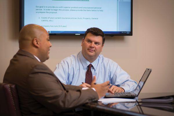 Darin Campbell, Principal with Benchmark discusses options for commercial insurance with a new client.