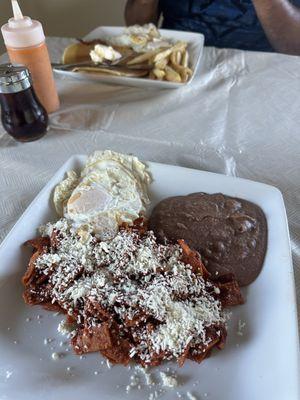 Chilaquiles rojos and pancake plate with bacon, eggs and fries