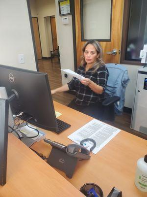 Dora, at the front desk. Smirking, statting it wasn't here who messed up my insurance while Smirking.