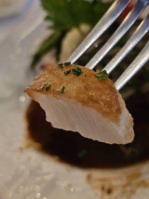 Half a scallop on a fork.