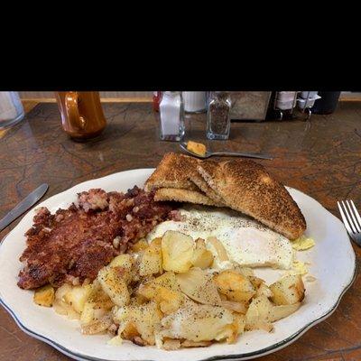 Two egg breakfast with hash, potatoes and wheat toast.