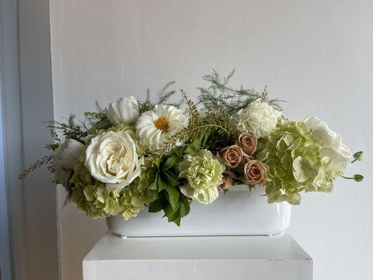 Long and low fresh floral centerpiece in a green and white color palette for a classic and timeless look.