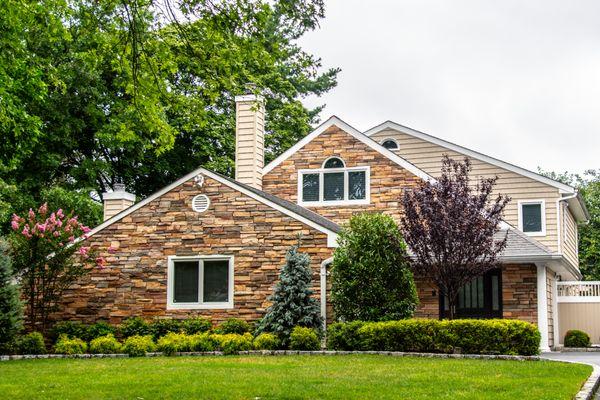 Boral cultured stone masonry accents with Charter Oak vinyl siding by Alside. GAF Weatherstopper Roofing System with Golden Pledge warranty.