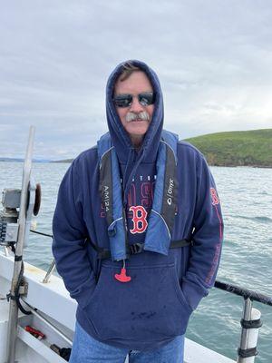 A passionate baseball coach enjoying an opportunity to see whales up close.