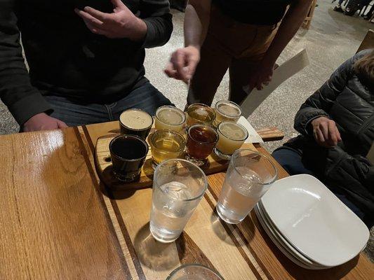 The server helping to explain the beers. Note: They tend to put 2 peoples flights on same tray to conserve table space.