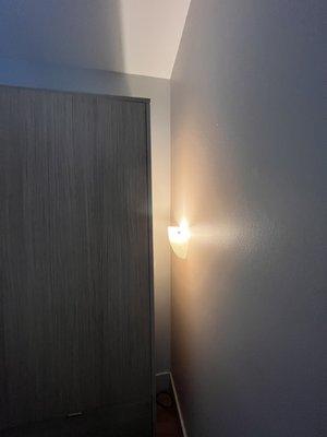 A lamp for no reason covered by the closet.