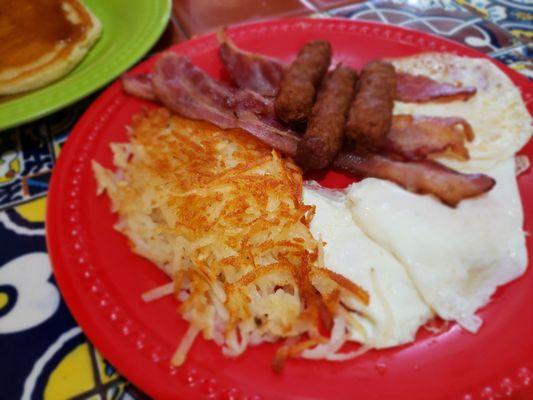 Jeff's Big Breakfast with 2 pancakes, perfectly crisped hashbrowns, fried eggs, sausage links, and bacon.