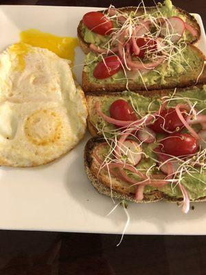 Avocado toast with two fried eggs, over easy