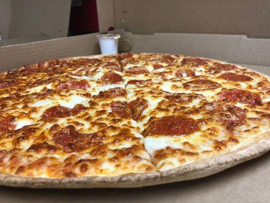 Thin Crust Pepperoni Pizza Served with a Side of Garlic Sauce