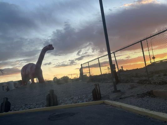 Large red dinosaur staring into the sunset