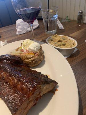 Baby back ribs with sides of loaded baked potato and squash casserole