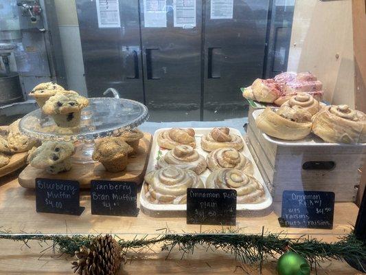 Spread of pastries available: blueberry muffin, bran muffin, cinnamon rolls