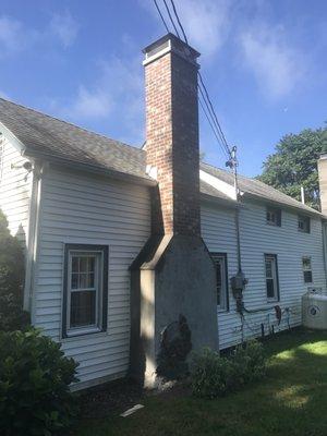 Completed rebuild with bluestone shoulders.. They left the little remanent of an older chimney exposed at the base at our request.