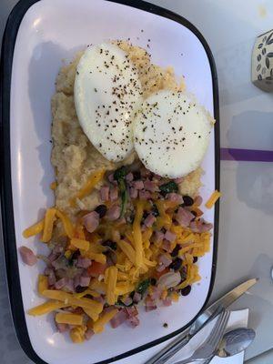 Poached eggs with cheesy grits and bit of ham, black bean.