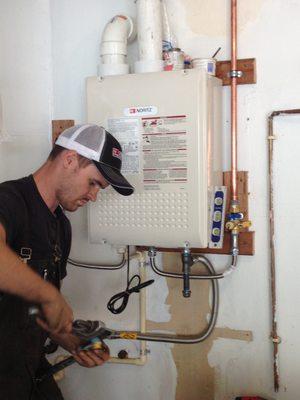 Nice, professional installation... Drew wanted to see if our level was 'square', so he 'tested' it on the side of the tankless water heater.