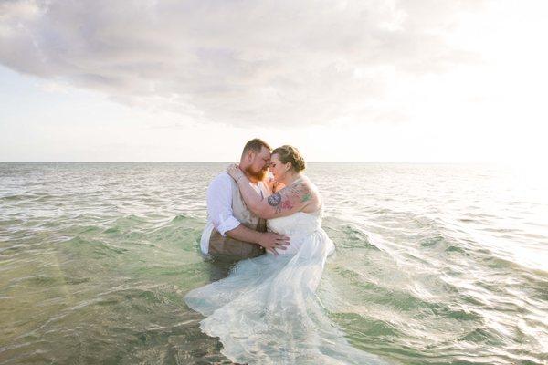 jumping in the water after beach wedding ceremony