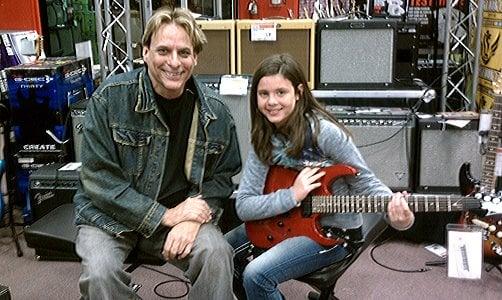 Award-winning composer, guitarist, and instructor Vince Lauria picking out a guitar with his student Samantha at Guitar Center.