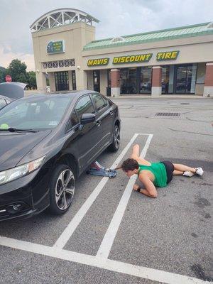 This is my son changing his tire in front of the store with all the idiots inside watching.