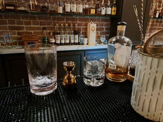 Making a Negroni at the bar. Square ice cube stamped with Daniellos lion logo.