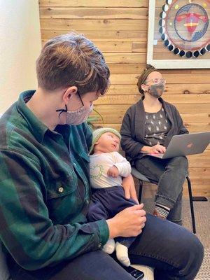 Catherine holding my baby and Sarah asking us questions at our final postpartum visit.