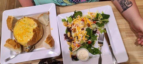 My wife got the cheddar broccoli soup in a bread bowl. And that is a half salad next to it.