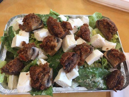 Caesar salad topped with fresh mozzarella and stuffed mushrooms